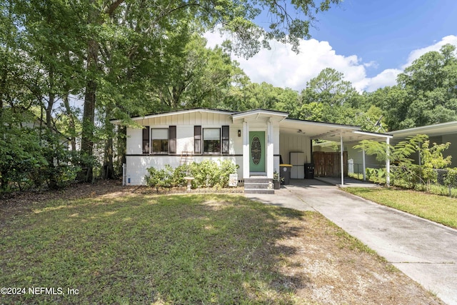 manufactured / mobile home with a carport and a front yard