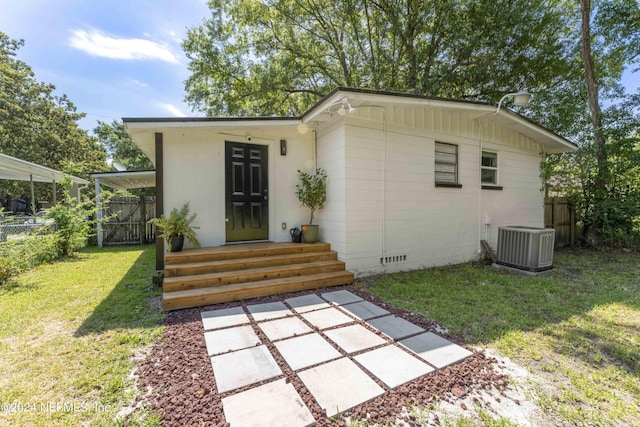 rear view of house with central air condition unit, a patio area, and a lawn