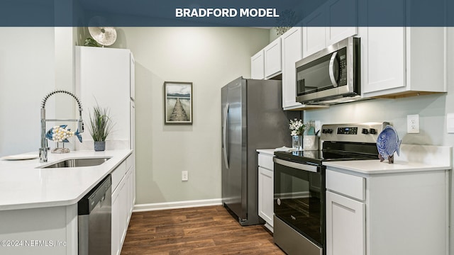 kitchen featuring a sink, stainless steel appliances, a peninsula, light countertops, and dark wood-style flooring