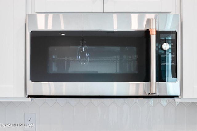 interior details featuring white cabinets and backsplash