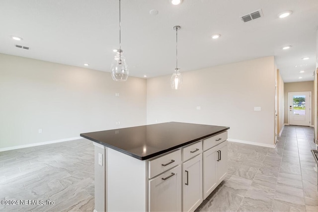 kitchen featuring decorative light fixtures, a kitchen island, and white cabinetry