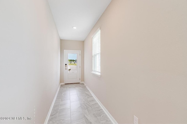 doorway to outside with light tile patterned floors and a healthy amount of sunlight