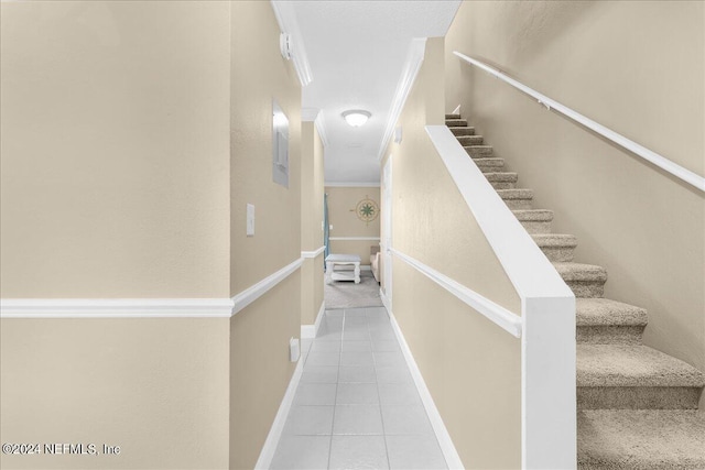 staircase featuring crown molding and tile patterned flooring