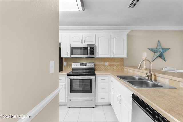 kitchen with decorative backsplash, stainless steel appliances, sink, light tile patterned floors, and white cabinets