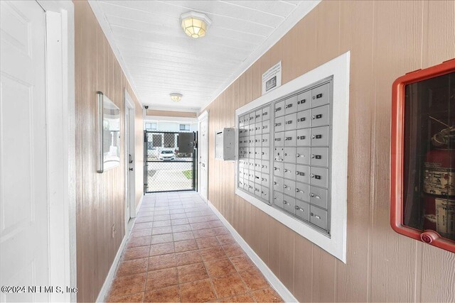 corridor with a mail area and wood walls