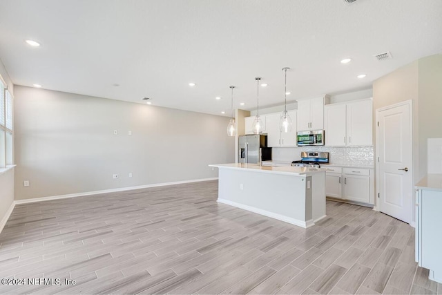 kitchen featuring white cabinetry, an island with sink, stainless steel appliances, and light hardwood / wood-style floors