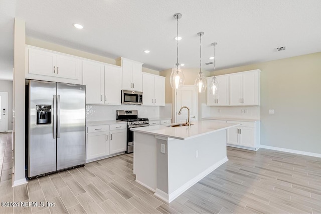 kitchen with pendant lighting, white cabinetry, sink, and appliances with stainless steel finishes