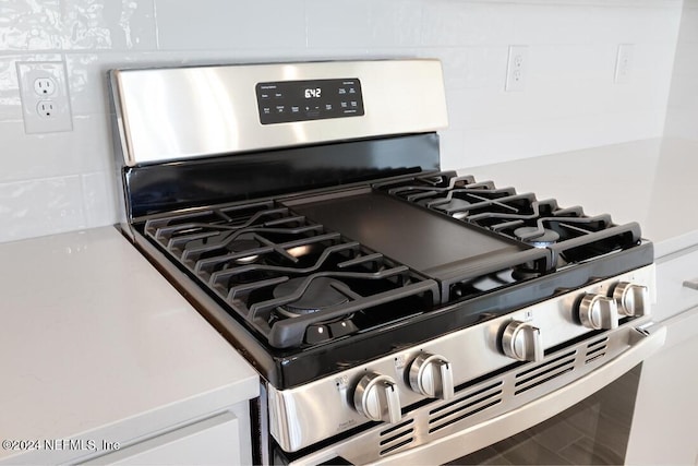 details with gas range and white cabinetry