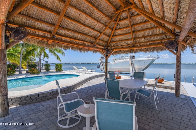 view of swimming pool featuring a patio area, a gazebo, and a water view