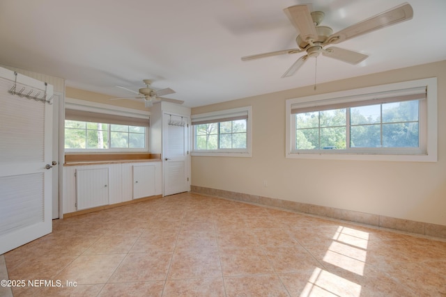 interior space with ceiling fan and light tile patterned floors