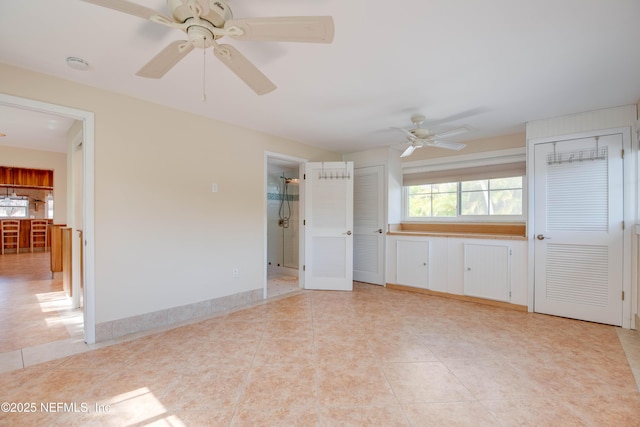 tiled empty room featuring ceiling fan