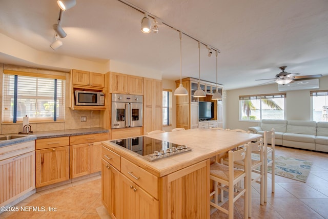 kitchen featuring pendant lighting, light tile patterned flooring, a wall mounted air conditioner, a kitchen island, and stainless steel appliances