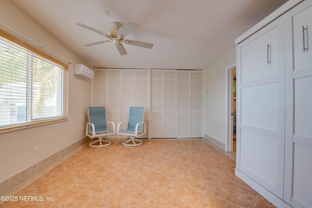 unfurnished room with a wall mounted AC, light tile patterned floors, and ceiling fan