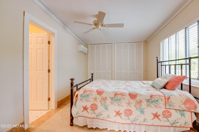 bedroom with an AC wall unit, light tile patterned floors, two closets, ornamental molding, and ceiling fan