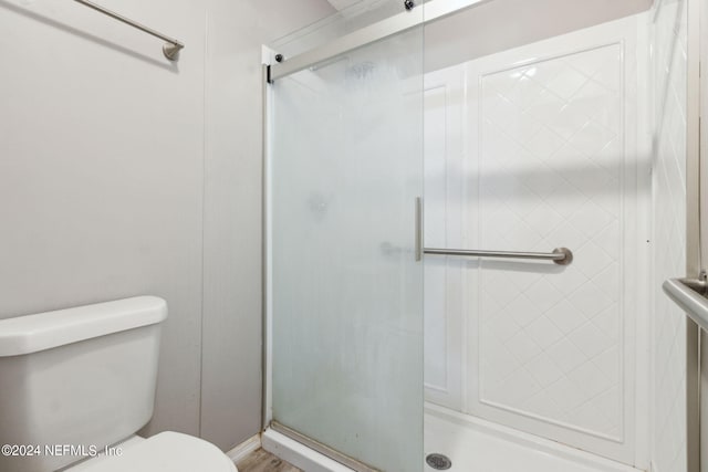 bathroom with a shower stall and toilet