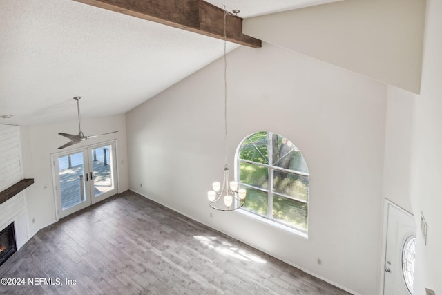 unfurnished living room with beam ceiling, french doors, wood finished floors, a glass covered fireplace, and high vaulted ceiling