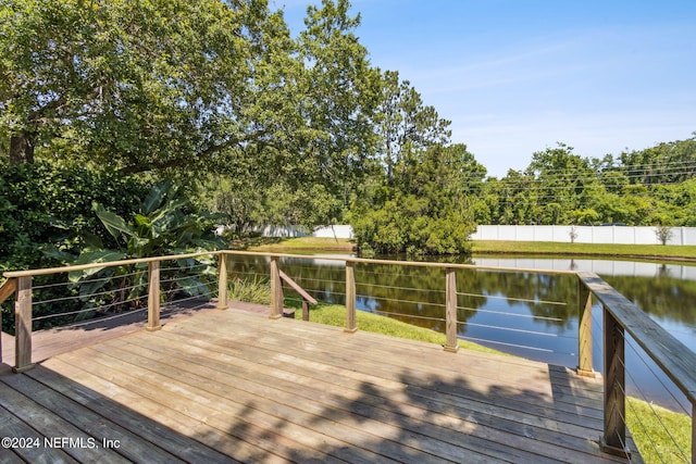 wooden deck featuring fence and a water view