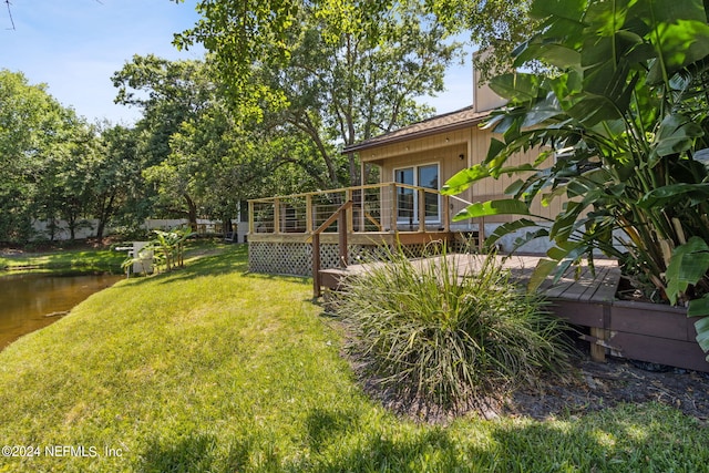 view of yard with a deck with water view