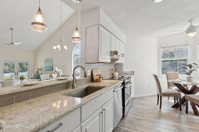 kitchen with under cabinet range hood, light stone countertops, ceiling fan, and a sink