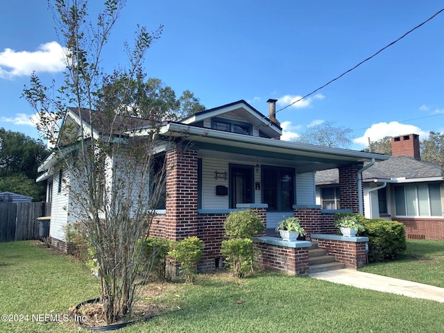 bungalow with covered porch and a front yard