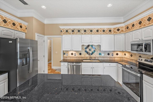 kitchen featuring white cabinets, appliances with stainless steel finishes, crown molding, and sink