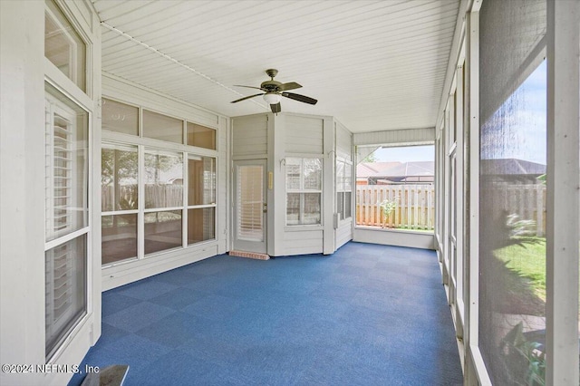 unfurnished sunroom with ceiling fan