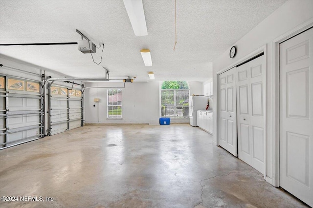 garage featuring a garage door opener and white refrigerator