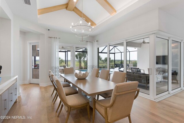 dining area featuring an inviting chandelier, lofted ceiling with beams, and light hardwood / wood-style flooring