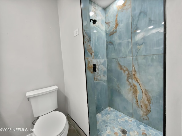 bathroom featuring toilet and tiled shower