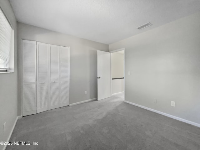 unfurnished bedroom featuring a closet, carpet floors, and a textured ceiling