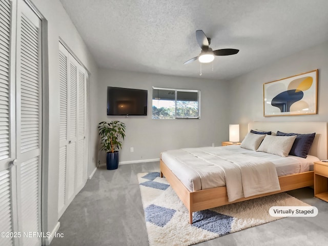 bedroom featuring a textured ceiling, light colored carpet, and ceiling fan