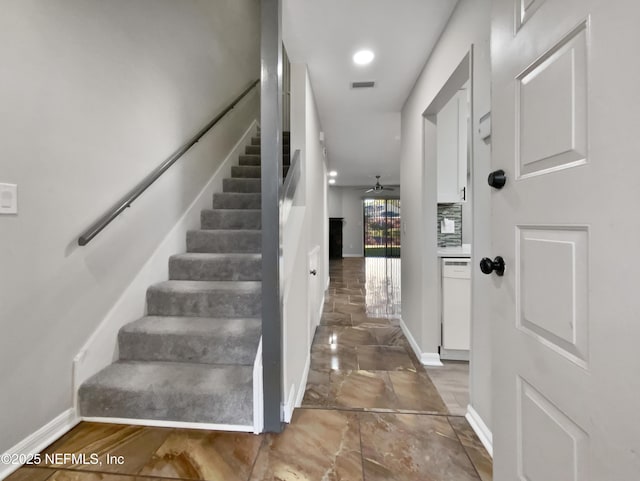 stairway featuring ceiling fan