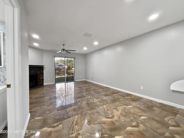 unfurnished living room with a fireplace and ceiling fan