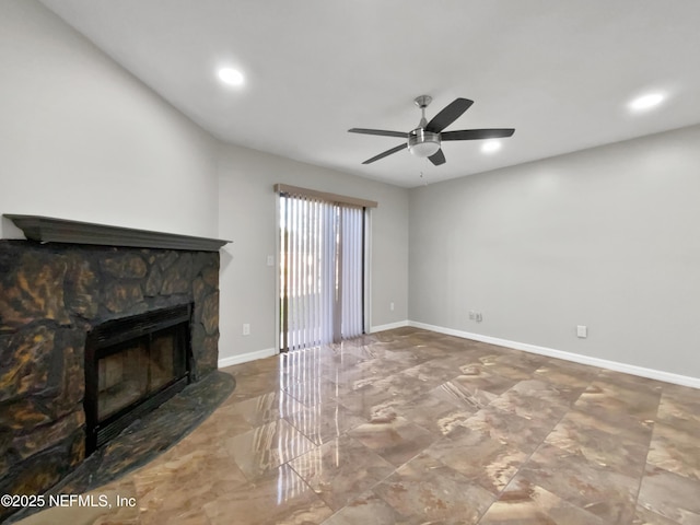 unfurnished living room featuring a stone fireplace and ceiling fan