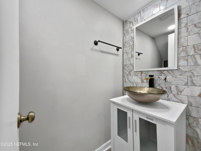 bathroom featuring vanity and tasteful backsplash