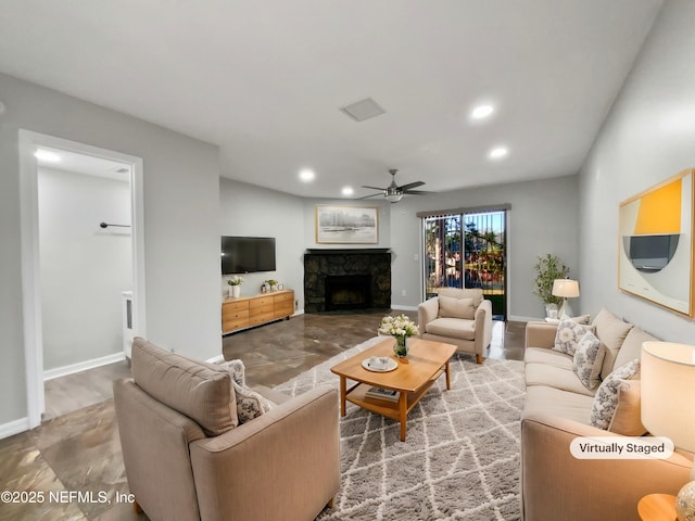 living room featuring ceiling fan and a fireplace