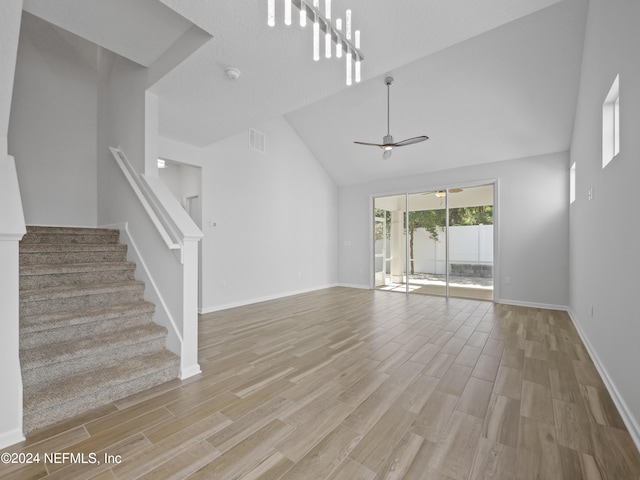 unfurnished living room featuring light hardwood / wood-style floors, high vaulted ceiling, and ceiling fan