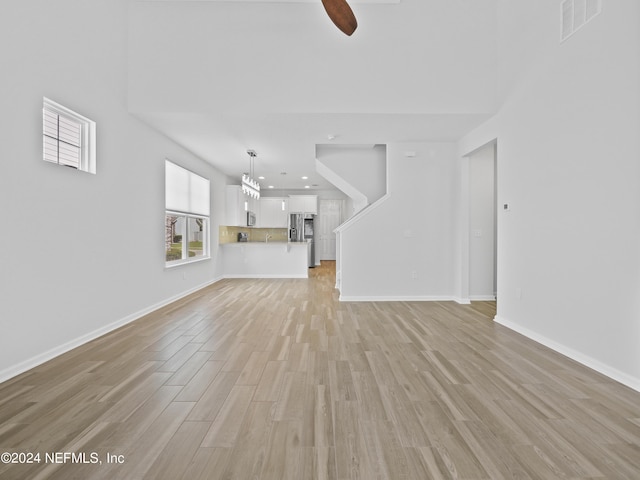 unfurnished living room with ceiling fan and light hardwood / wood-style floors