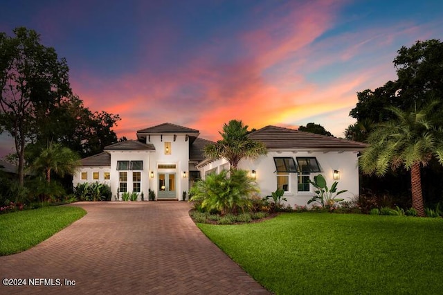 mediterranean / spanish home featuring a yard and french doors