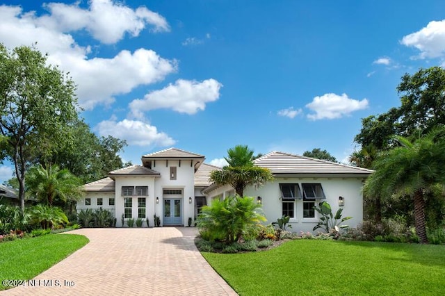 mediterranean / spanish-style house featuring a front lawn and french doors