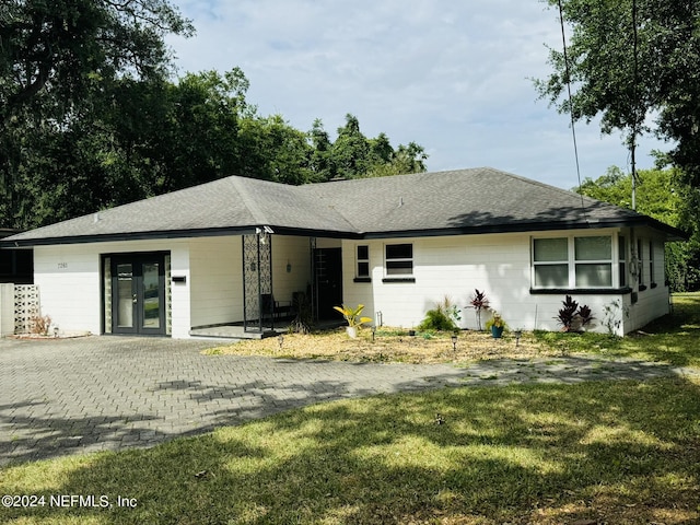 single story home with french doors and a front lawn