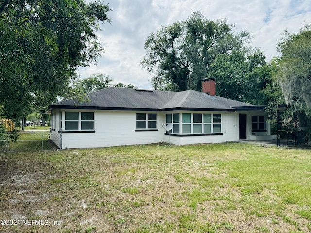 back of property featuring a yard