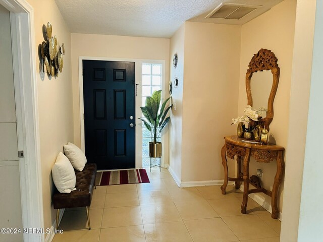 tiled entryway with a textured ceiling