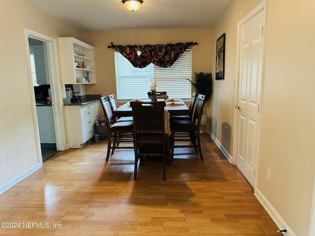 dining room with wood-type flooring and a textured ceiling