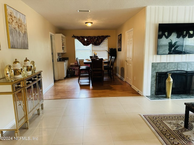 dining area with a fireplace, a textured ceiling, and light wood-type flooring