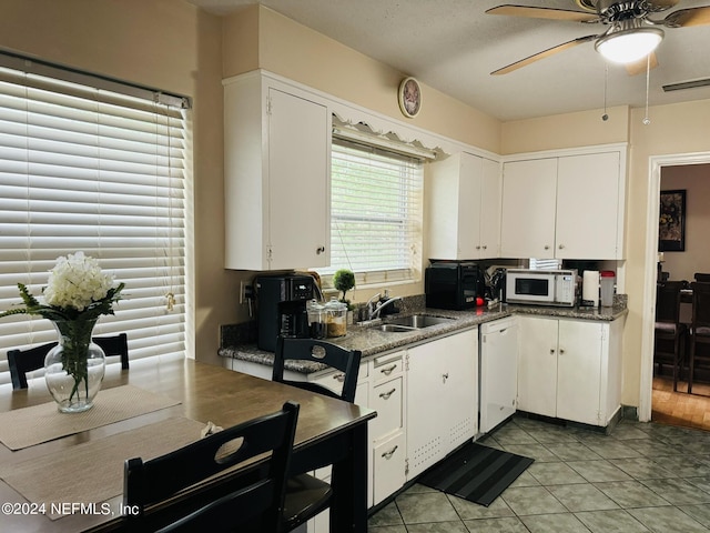 kitchen with white appliances, a textured ceiling, sink, light tile patterned floors, and white cabinetry