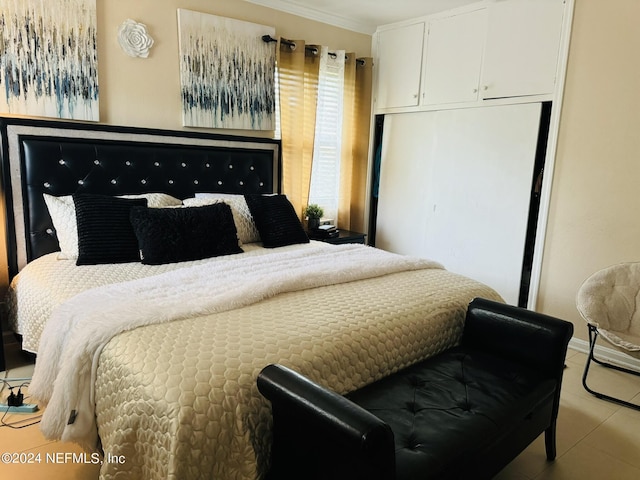 tiled bedroom featuring a closet and ornamental molding