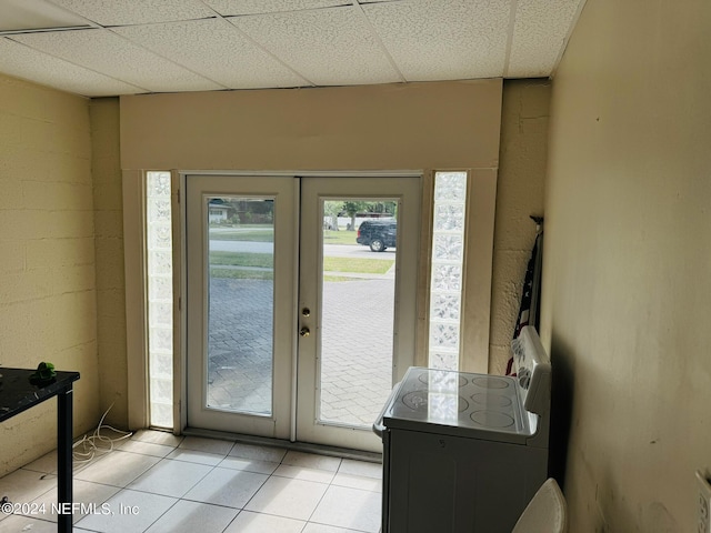 entryway with french doors, light tile patterned floors, and a drop ceiling