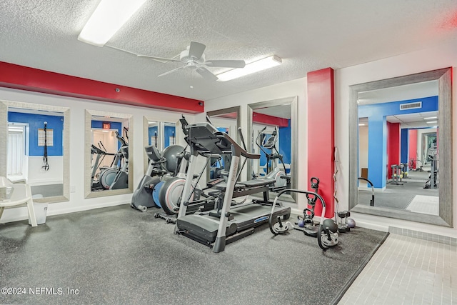 exercise room with ceiling fan and a textured ceiling