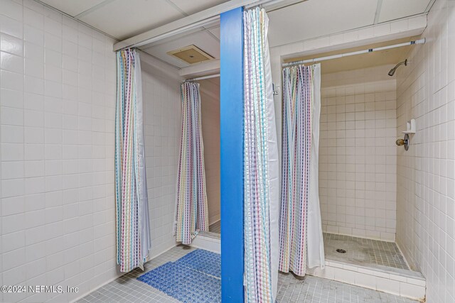 bathroom featuring tile patterned flooring and a tile shower